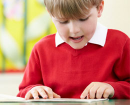 boy reading red jumper